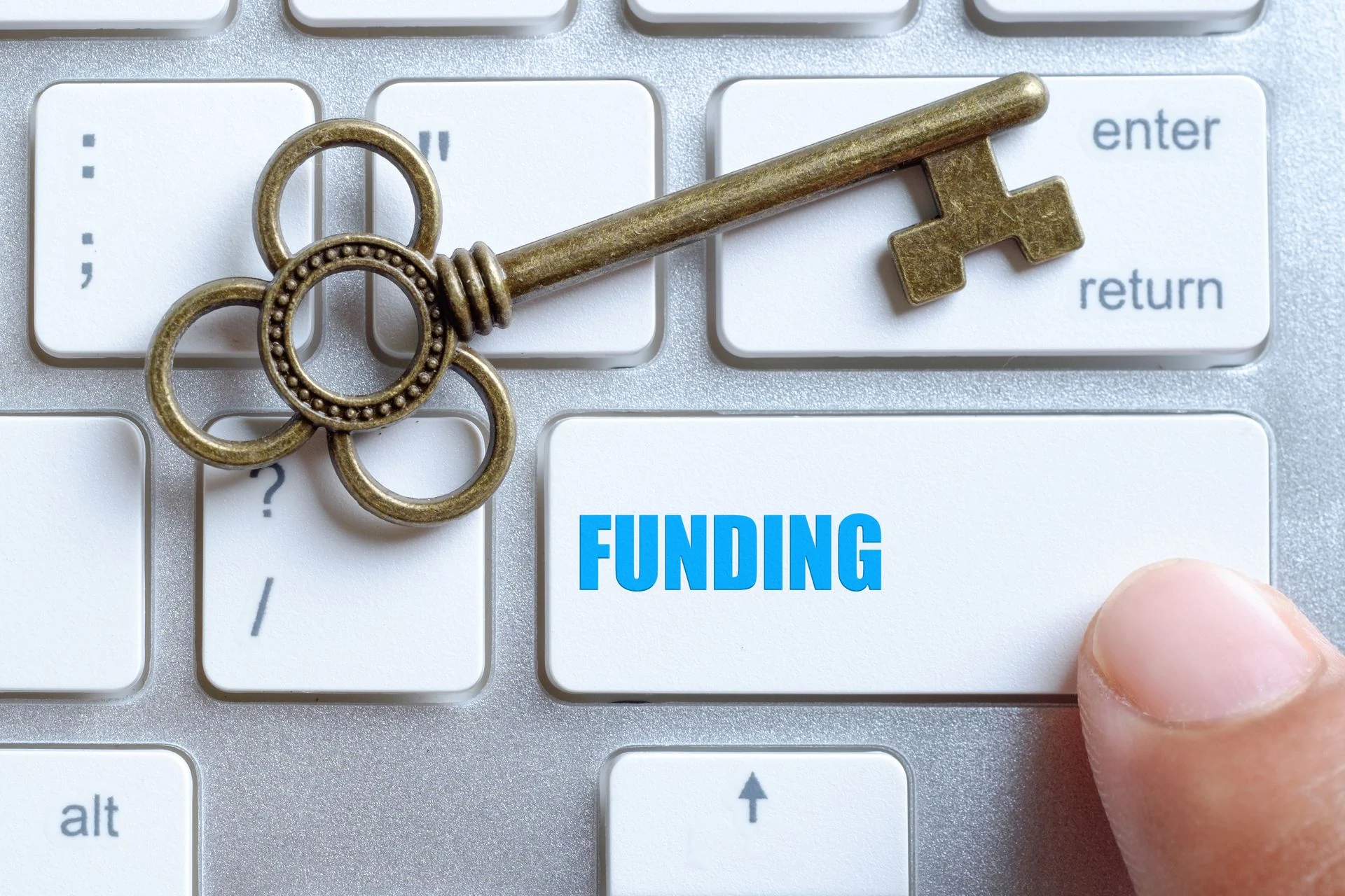 Closed up finger on keyboard with word Funding